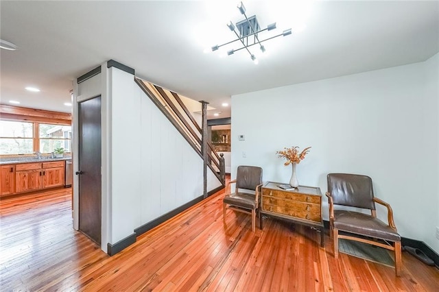 sitting room with light wood-style floors, recessed lighting, and stairs