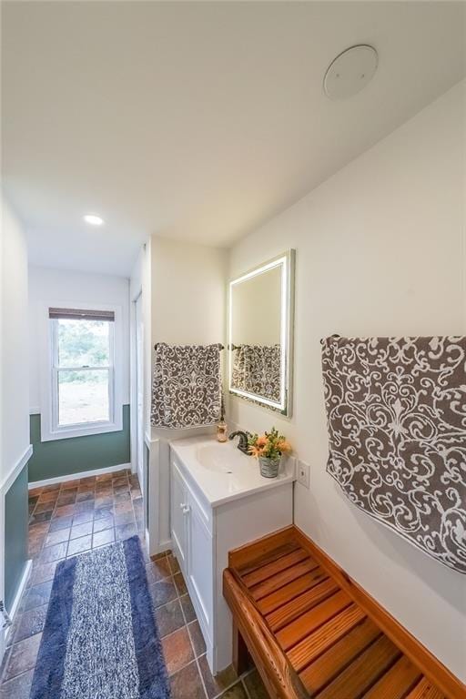 mudroom featuring stone tile flooring, baseboards, recessed lighting, and a sink