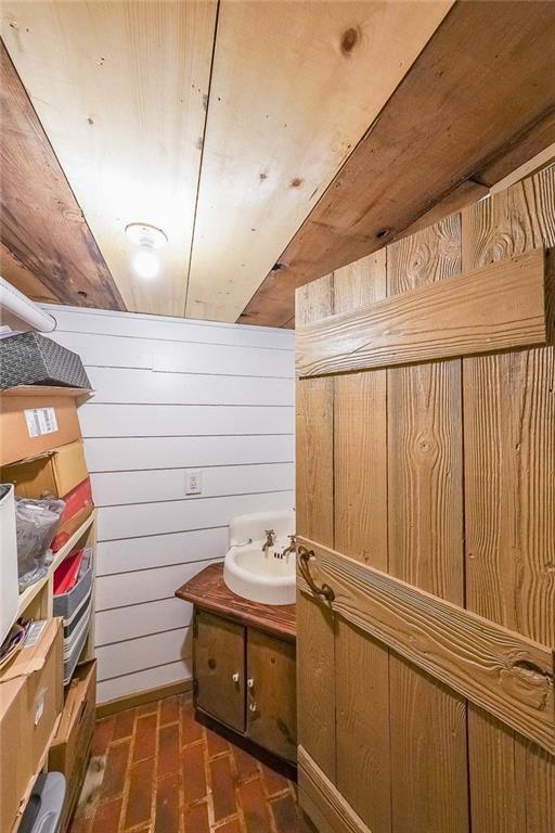 bathroom with wood walls and vanity