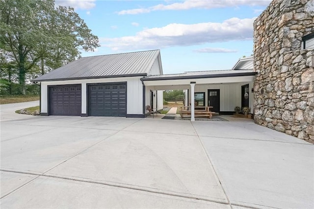 garage with driveway and covered porch