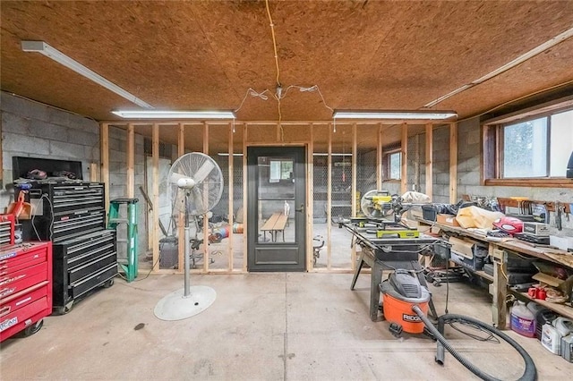 miscellaneous room featuring a workshop area and concrete flooring