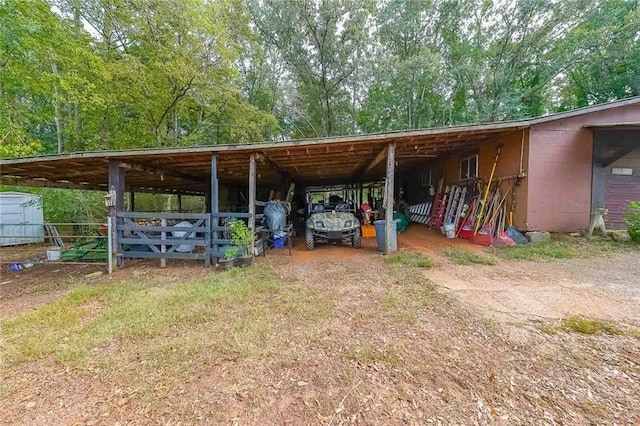 view of parking / parking lot with an outbuilding, driveway, and an attached carport