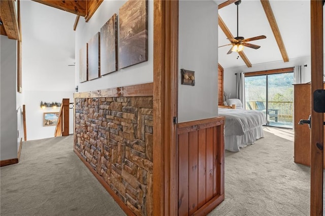 hallway with beamed ceiling, carpet flooring, and high vaulted ceiling