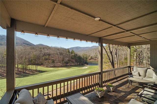 wooden deck featuring golf course view and a mountain view