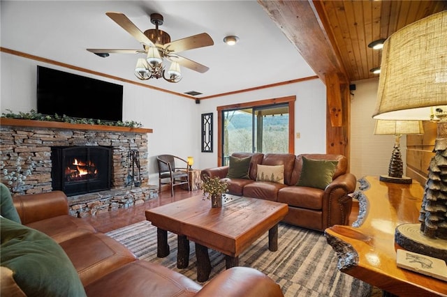 living room with visible vents, a ceiling fan, wood finished floors, a fireplace, and crown molding