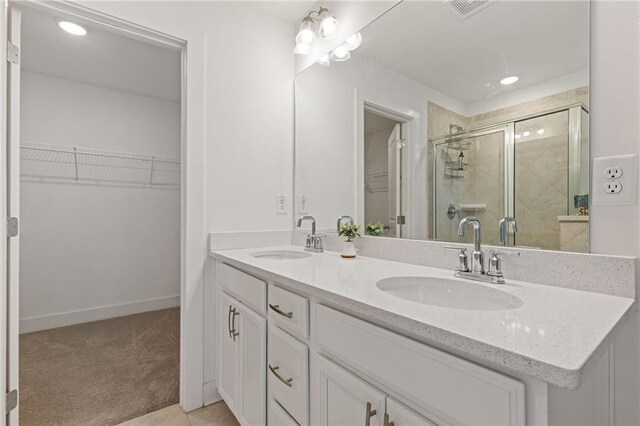 bathroom with walk in shower, vanity, and tile patterned flooring