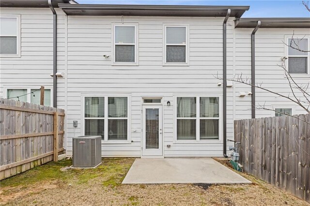 back of house featuring central AC, a patio, and a lawn