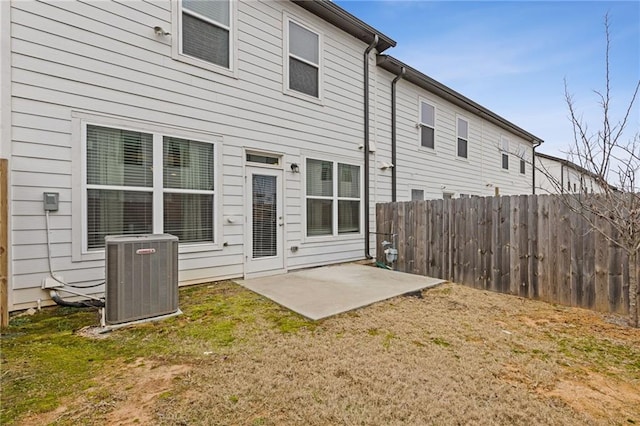 rear view of property featuring cooling unit, a yard, and a patio area