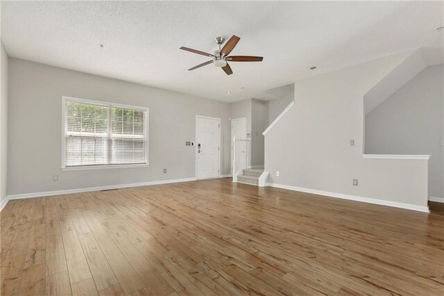 1122 Cotton Gin Dr, Woodstock, GA 30188 - unfurnished living room featuring a ceiling fan, wood-type flooring, stairway, and baseboards