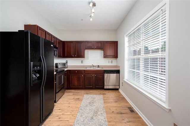 1122 Cotton Gin Dr, Woodstock, GA 30188 - kitchen with appliances with stainless steel finishes, a sink, light countertops, tasteful backsplash, and light wood-type flooring