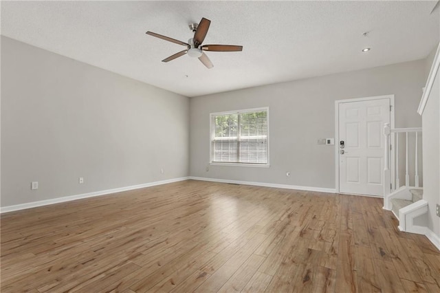 1122 Cotton Gin Dr, Woodstock, GA 30188 - unfurnished room featuring ceiling fan, light wood-type flooring, stairway, baseboards, and a textured ceiling