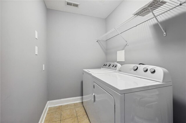 laundry room featuring light tile patterned floors and washing machine and dryer