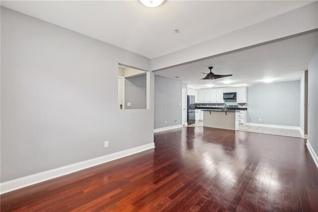 unfurnished living room featuring wood-type flooring and ceiling fan