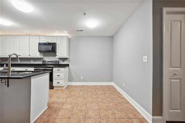 kitchen with a breakfast bar, white cabinets, kitchen peninsula, light tile patterned floors, and electric range