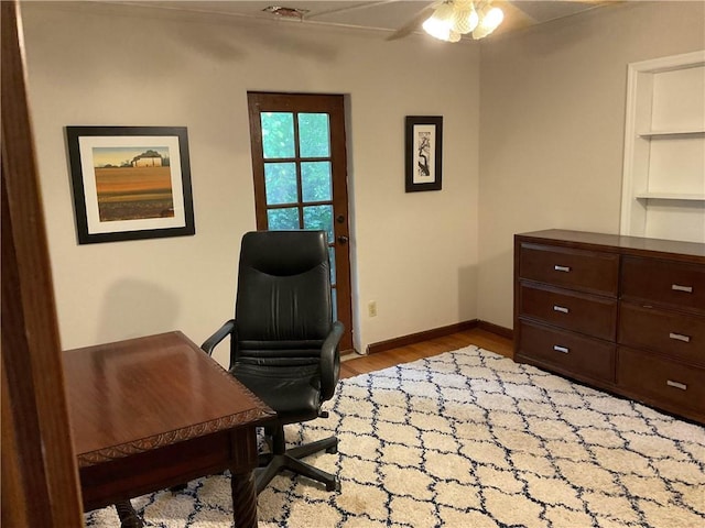 office area with visible vents, light wood-style flooring, ceiling fan, and baseboards