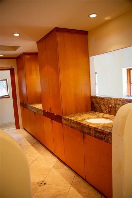 bathroom featuring recessed lighting, a tub to relax in, a sink, and tile patterned flooring