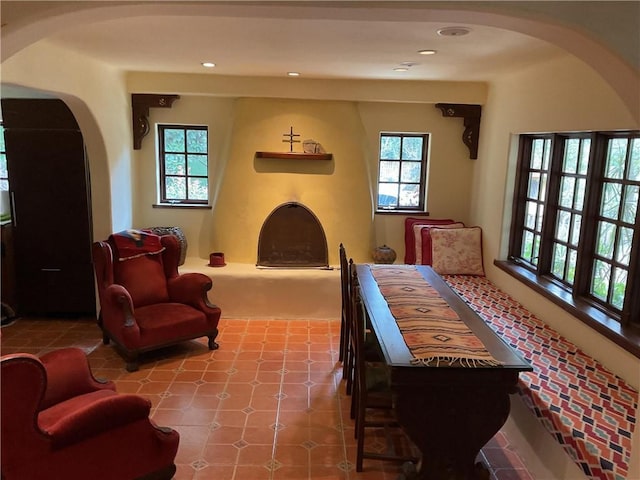living area featuring a wealth of natural light, arched walkways, and recessed lighting