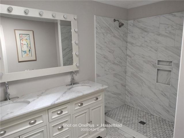 full bathroom with double vanity, a tile shower, a sink, and crown molding