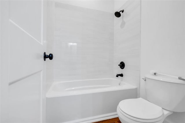 bathroom featuring tiled shower / bath and toilet