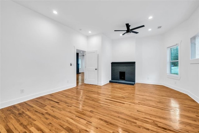 unfurnished living room with ceiling fan, light hardwood / wood-style flooring, and a fireplace