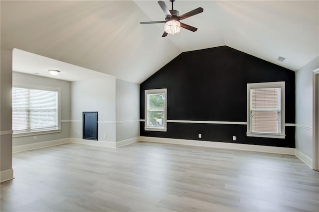 unfurnished living room with light wood finished floors, a ceiling fan, vaulted ceiling, and baseboards
