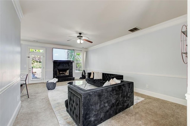 living room featuring crown molding, ceiling fan, a fireplace, carpet flooring, and baseboards