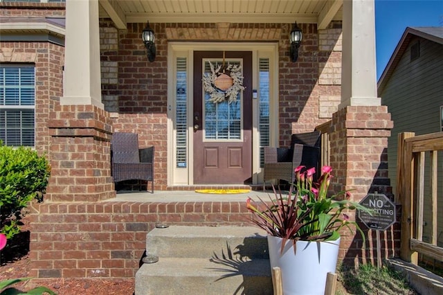property entrance with brick siding and a porch