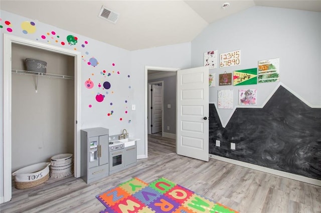 game room with light wood-type flooring and lofted ceiling