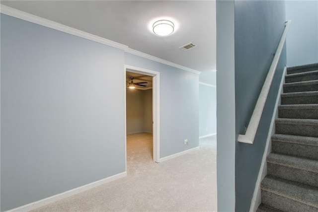 stairway with ceiling fan, carpet, baseboards, and ornamental molding