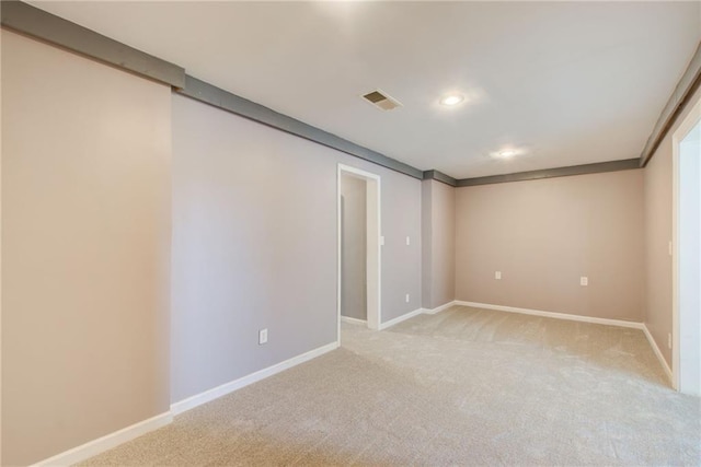 spare room featuring light carpet, baseboards, and recessed lighting