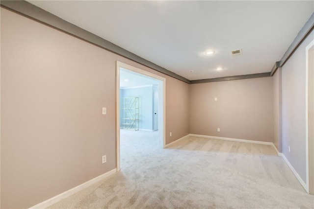 empty room featuring light carpet, baseboards, and recessed lighting