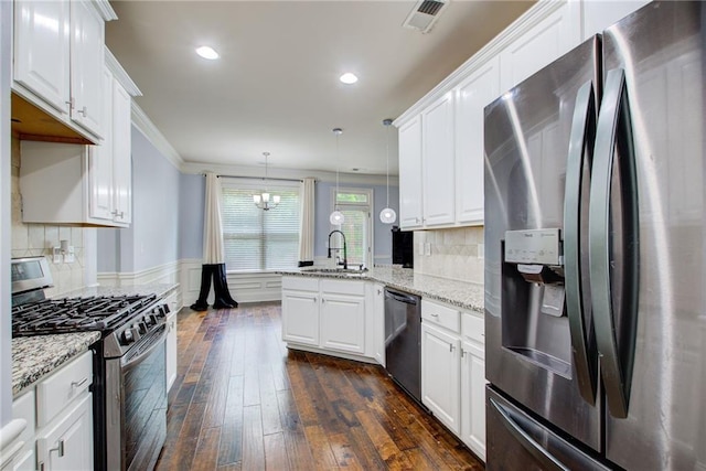 kitchen with appliances with stainless steel finishes, a peninsula, white cabinets, dark wood-style floors, and recessed lighting