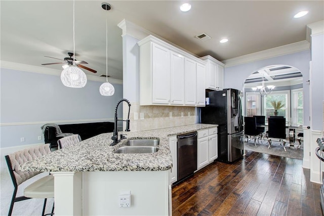 kitchen with dishwasher, a sink, ornamental molding, arched walkways, and freestanding refrigerator