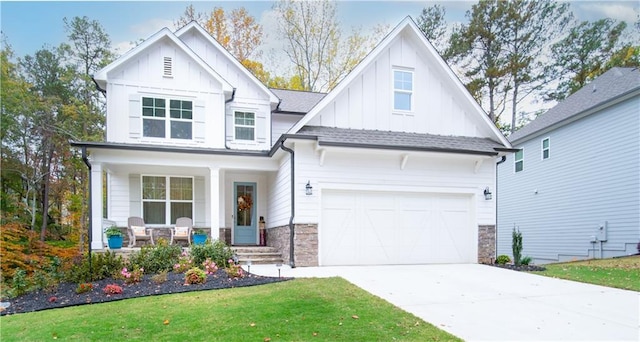 view of front of home featuring a porch, a garage, and a front lawn