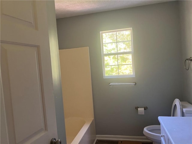 bathroom featuring a textured ceiling, vanity, and toilet