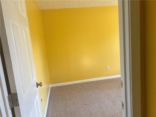 carpeted empty room featuring a textured ceiling