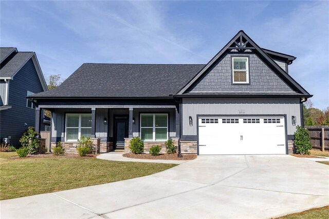 craftsman house featuring a front yard and a garage