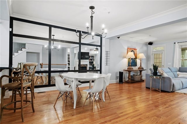 dining space with a notable chandelier, crown molding, and wood-type flooring