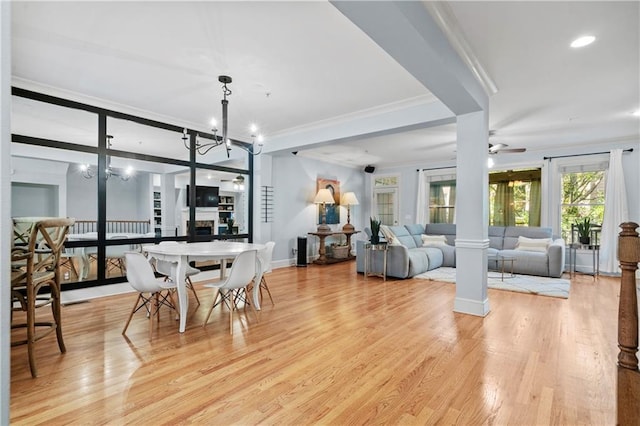 dining space featuring ceiling fan with notable chandelier, light hardwood / wood-style flooring, and ornamental molding