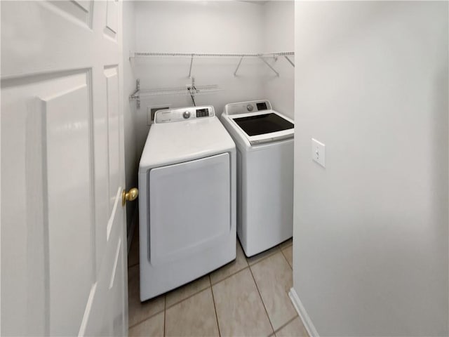 laundry area with laundry area, light tile patterned flooring, and washer and clothes dryer