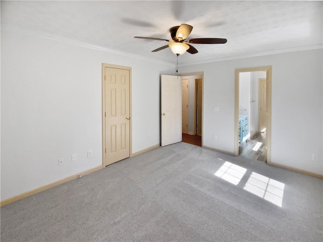 unfurnished bedroom with carpet floors, ceiling fan, baseboards, and crown molding