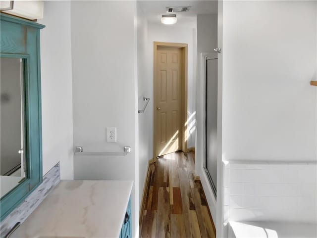 hallway featuring visible vents and wood finished floors