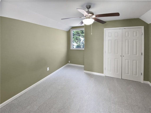 unfurnished bedroom with carpet floors, baseboards, and vaulted ceiling