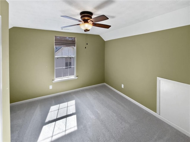 empty room with visible vents, baseboards, lofted ceiling, ceiling fan, and carpet