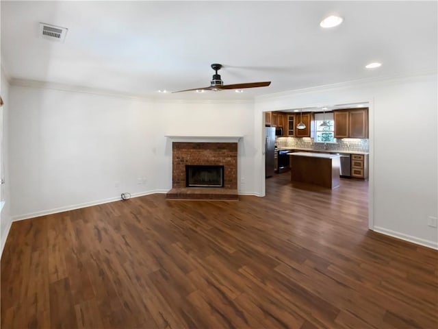 unfurnished living room featuring ornamental molding, dark wood-style flooring, and visible vents