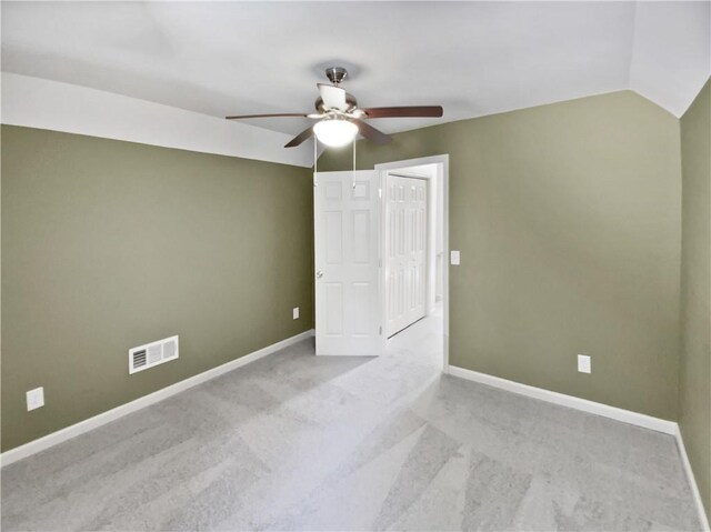 unfurnished room with baseboards, visible vents, vaulted ceiling, and a ceiling fan