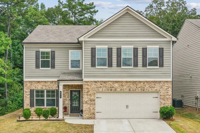 view of front of home with a lawn, a garage, and central AC unit