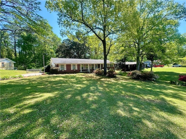 view of front of house with a greenhouse and a front lawn