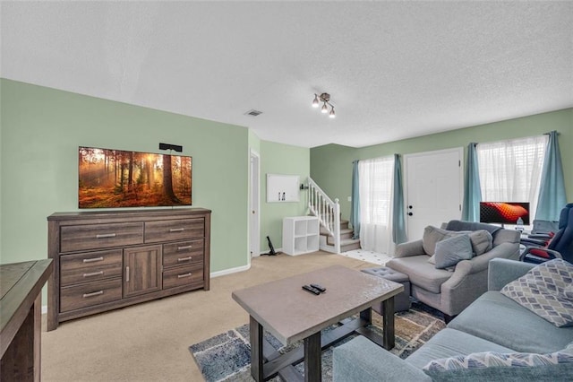 6178 Field Stone Dr, Douglasville, GA 30134 - living room featuring healthy amount of natural light, light colored carpet, a textured ceiling, and stairway