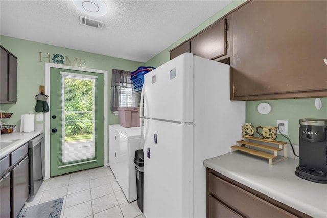 6178 Field Stone Dr, Douglasville, GA 30134 - kitchen featuring freestanding refrigerator, washing machine and dryer, a textured ceiling, light countertops, and dishwasher